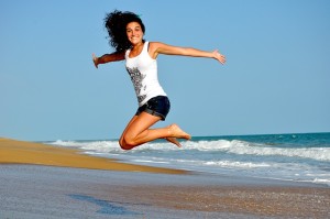 Happy girl jumping on beach